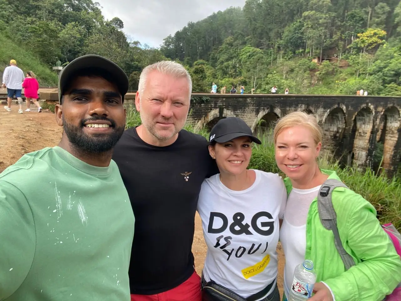 Naveen with three guests at Nine Arch Bridge, the viaduct visible through the trees