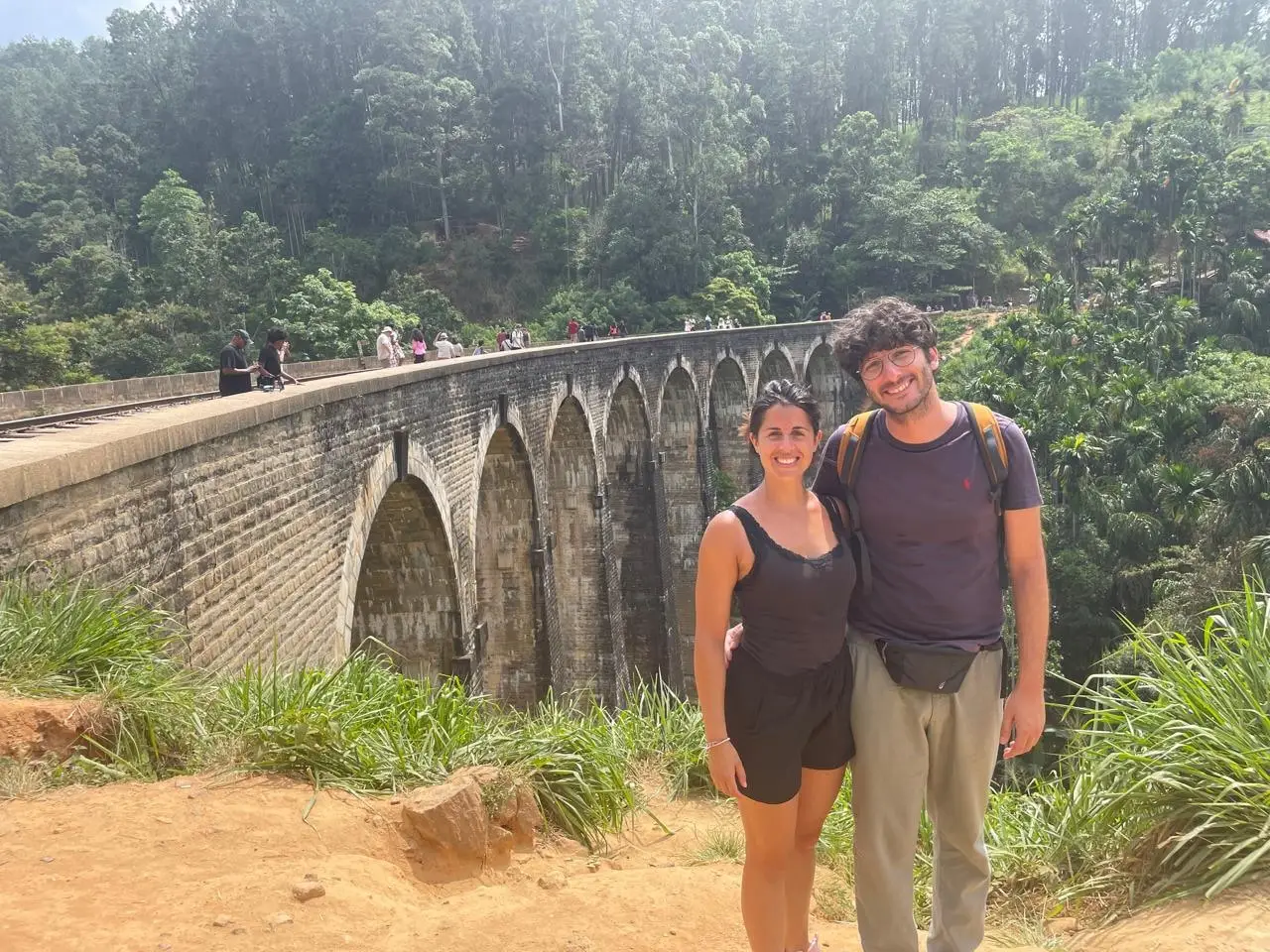 A couple on the walking path beside Nine Arch Bridge, the arches running away behind them